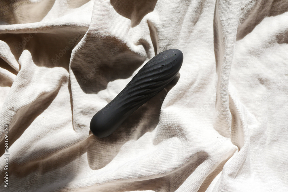 Black vibrator lay on bed. Sex toys concept. Women sexual health Stock  Photo