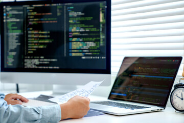 Wall Mural - programmer writing program code with two monitors and working on a new software or hacker programmin