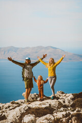 Wall Mural - Family hiking in Greece parents with child travel outdoor mother and father raised hands active summer vacations healthy lifestyle eco tourism in Rhodes island mountain top