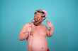 Beauty and skin care. Funny fat man washes in the shower in a cosmetic mask.