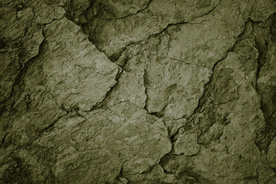 Wall Mural -  - Olive green grunge background. Cracked rough stone surface. Close-up. Broken, crumbled.