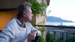 One pensive senior man looking at scenic landscape during sunset time in contemplation. Thoughtful older male person in 70s enjoying retirement sitting by view