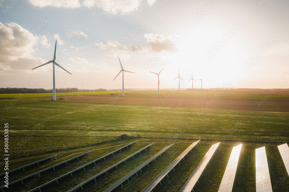 Wind turbines and solar panels farm in a field. Renewable green energy ...