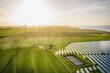 Wind turbines and solar panels farm in a field. Renewable green energy. Sunny landscape, electric energy generator for clean energy producing concept.