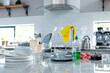 © Wavebreak Media - Yellow washing up gloves on faucet with dirty dishes and soap dispenser on kitchen counter