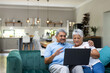 © Wavebreak Media - Biracial senior couple talking over video call on laptop while relaxing on sofa at home