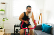 © AntonioDiaz - Happy man sweating while riding his stationary bike