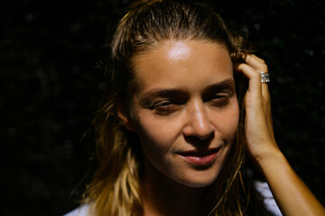 Portrait of a natural beautiful woman close-up, outside, dark background.