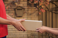 Man Receiving Parcel From Courier Outdoors, Closeup