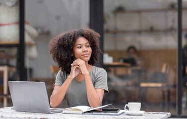 Shot of a young business african american woman reading a text while sitting at an outdoor cafe.