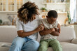 © DimaBerlin - Loving african american mother embracing hugging sad little son supporting child, mom parent trying to make peace with offended upset kid, sitting together on sofa at home. Parent-child conflict