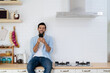 © jittawit.21 - Handsome young man happy while sitting at home kitchen in good morning on leisurely vacation. Cheerful young bearded man talking on