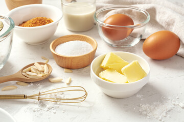 Wall Mural - Baking pastry or cake ingredients, butter, sugar, flour, eggs and milk with whisk on marble table