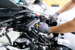 © Deemerwha studio - Professional car mechanic using a wrench for working on the engine of the car in the garage for car auto repair service and maintenance check concept for the car before leaving.
