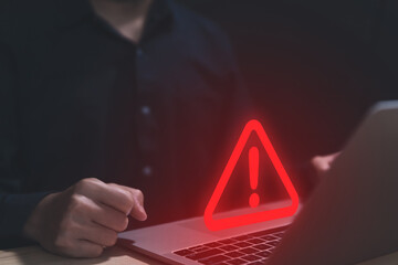 Wall Mural - businessman using laptop showing warning triangle and exclamation sign icon caution of dangerous pro