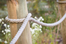 Closeup Of Fence Made Of Rope And Wooden Pole In Park