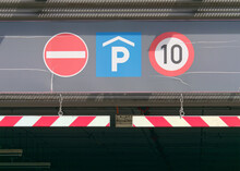 Close-up Photo Of A No Entry, Parking, And Speed Limit Ten Traffic Signs At The Top Of The Entrance To The Underground Garage