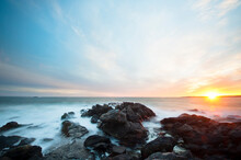 Scenic view of rocky shore during sunset