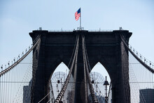 Low Angle View Of American Flag On Brooklyn Bridge Against Clear Sky