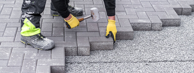 rubber hammer for adjusting the lock paving on the sidewalk. banner with copy space