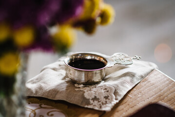 Wedding bowl in the church on the table. Silver cup of blood. A silver chalice of communion wine. Close up. Divine Liturgy. Details of the wedding ceremony in the church.