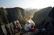 Backpacker couple enjoy travel through Southeast Asia contemplating the views of Mua Cave, Vietnam