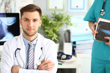 Portrait of a young doctor in a clinic with an assistant