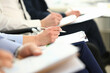 © H_Ko - Businessmen are holding documents while taking notes at seminar