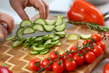 Wall Mural - Cutting vegetables with knife for cooking on board