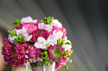 Beautiful Spring Flowers Bouquet Made Of Roses, Freesia And Peonies Vivid Color Plants Against Grey Background.