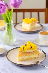 Wall Mural - Sliced biscuit cake with cream cheese cream, lemon layer and yellow biscuit decor on a ceramic plate on a light background. Recipes for biscuit cakes.