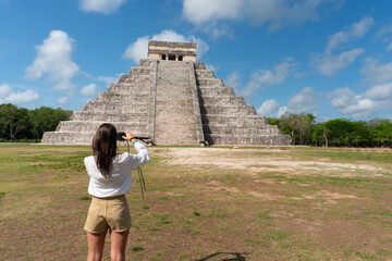 Tourist girl in front of the background of the Kukulcan pyramid in the Mexican city of Chichen Itza. Travel concept.Mayan pyramids in Yucatan, Mexico