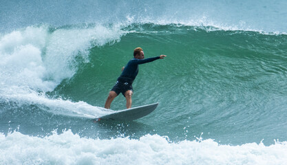 Poster - Surfer rides the stormy wave in the cold water. Cold water surfing in Brazil