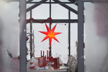 Red Christmas Star And Decorations On Table