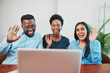 © Meeko Media - Three colleagues smile and wave at laptop screen, remote meeting conference call