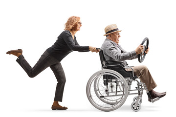 Wall Mural - Woman pushing a mature man in a wheelchair holding a steering wheel