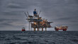 Picture of offshore oil and gas production in the sea in stormy weather at dusk.
Jack up, semi submersible rigs crude oil production in ocean.