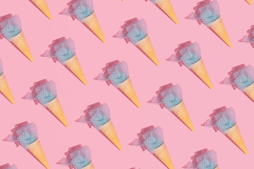 Creative ice cream made of pastel blue ribbon, summer holidays pattern, candy pink background.