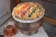 Closeup shot of variety of delicious sweets in antique copper pot with cup of coffee