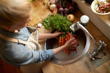 Canvas Print - Washing them off before its time to cook. High angle shot of a woman washing carrots in a sink.