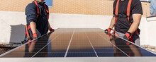 two handymen workers installing solar panel