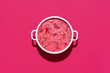 canvas print picture - Beetroot soup with sour cream in a white bowl, isolated on magenta background