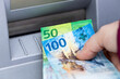The woman is holding Swiss money taken from an ATM, 100 and 50 franc paper banknotes