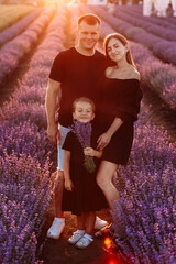 Wall Mural - happy family day. young father, mother and child daughter are having fun together in the lavender field. happy couple with kid enjoy summer holiday vacation. family look