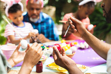 Happy African American Family Coloring Easter Eggs In Garden