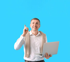 Poster - mature man with laptop pointing at something on blue background