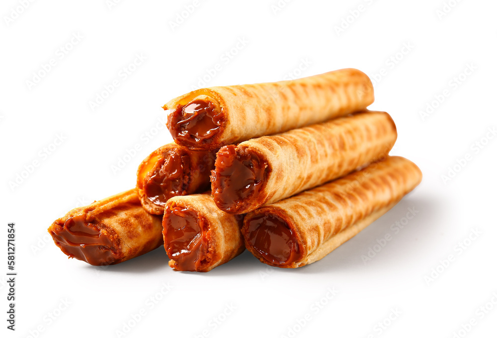 Stack of delicious wafer rolls with boiled condensed milk isolated on white background