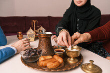 Happy Muslim Couple Wife Serving Turkish Coffee To Her Husband After Dessert At Home During The Eid Mubarak Ramadan.