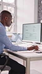 Wall Mural - Young Businessman Looking At Invoice While Doing Online Banking