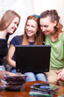 © danmorgan12 - Modern Lifestyle. Three Young Positive Laughing Caucasian Girlfriends Having Fun With Personal Laptop Computer Indoors.